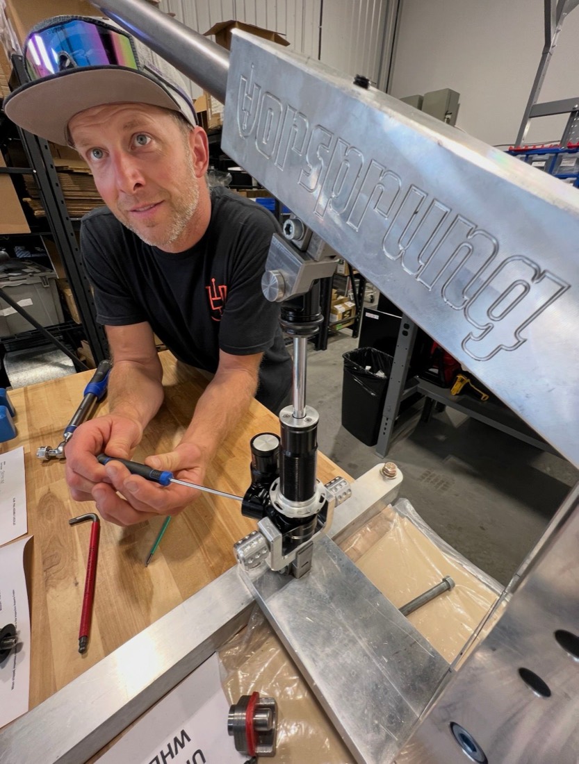 Geoff working on a shock with a precision screwdriver at a suspension service bench in Kamloops